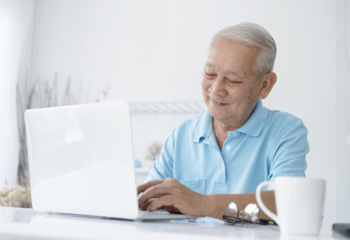 Happy senior man working on laptop and holding cof 2023 11 27 05 02 05 utc