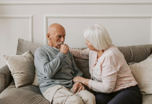 Senior man coughing with his wife comforting him